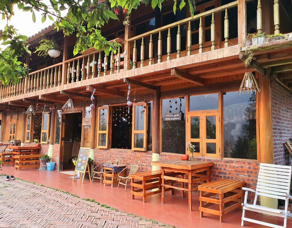 un patio con mesas de madera y sillas en un edificio en La Beauté Sa Pa, en Sa Pa