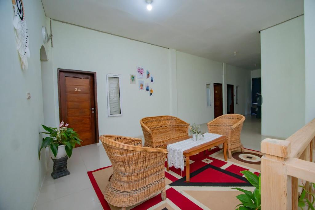 - un salon avec des chaises en osier et une table dans l'établissement RedDoorz Syariah near Rembele Airport Bener Meriah, à Tingkeum