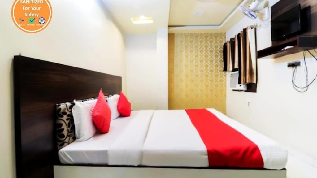 a bedroom with a bed with red and white pillows at HOTEL KABIR in Lucknow