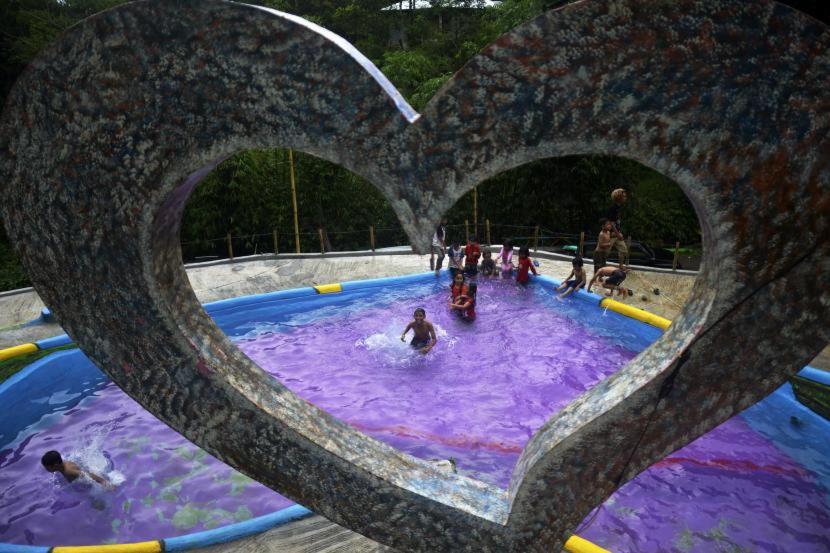 a group of people in a swimming pool in a heart shape at Bamboo Park & Resort Malino in Malino