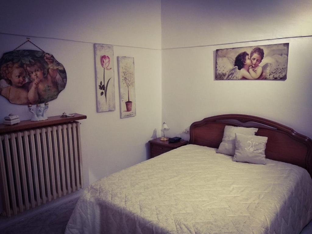 ein Schlafzimmer mit einem Bett und einem Heizkörper und Bildern in der Unterkunft Antica Dimora 1848 in Biccari