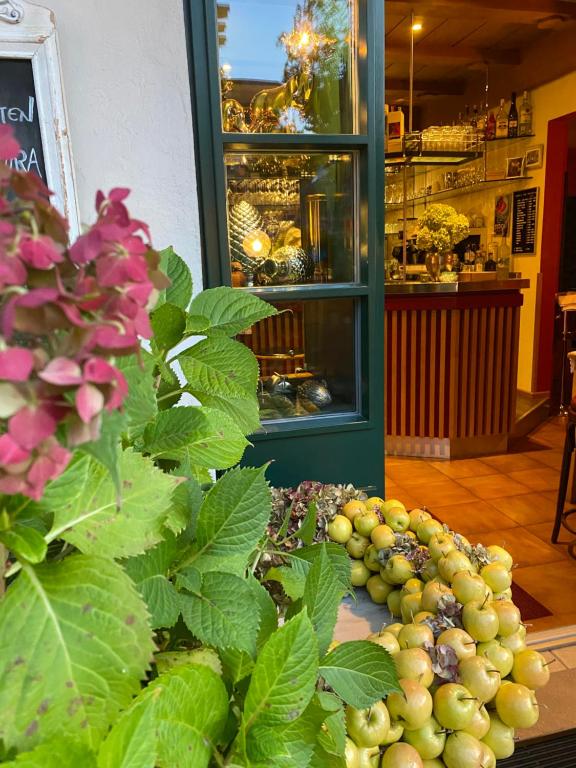 Un grappolo d'uva su un tavolo di fronte a un negozio di B&B Pizzeria Zur Traube a Montagna