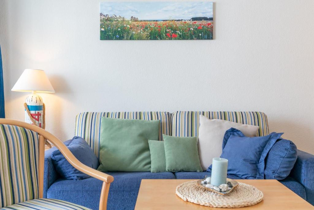 un soggiorno con divano blu e cuscini colorati di Seepark Sellin FeWo AG Whg 446 a Ostseebad Sellin