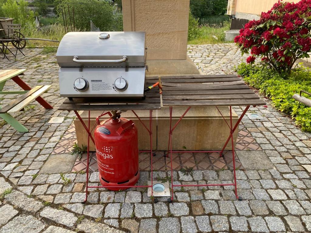 a grill on a picnic table next to a fire hydrant at Ferienhaus WAFFENKAMMER für 7 Erw im Rittergut Leppersdorf in Wachau