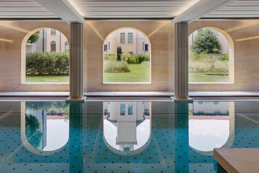 une piscine intérieure avec des fenêtres et de l'eau dans un bâtiment dans l'établissement Villa Maïa, à Lyon