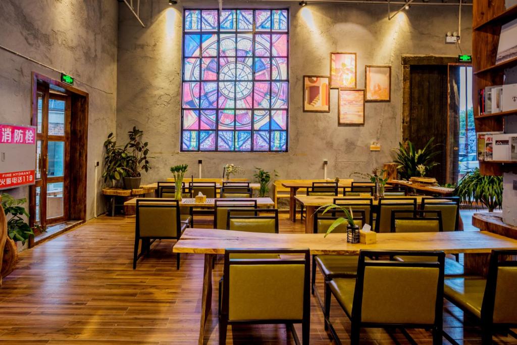 a restaurant with tables and a stained glass window at Guilin Changshe Hotel in Guilin
