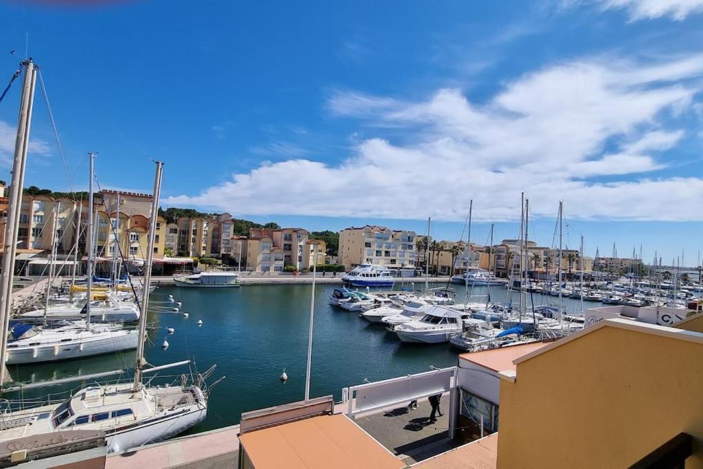 grupa łodzi zacumowanych w porcie z budynkami w obiekcie Magnifique Studio sur le Port de Gruissan (2 à 4 pers) w mieście Gruissan