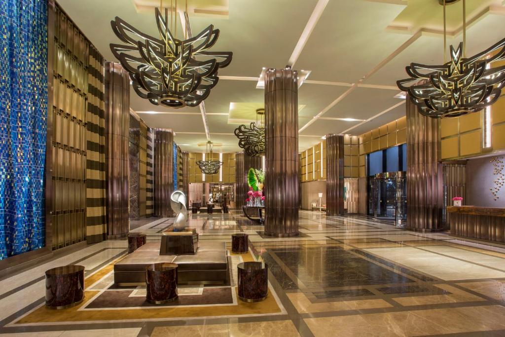 a lobby of a hotel with columns and chandeliers at City Of Dreams - Nüwa Manila in Manila