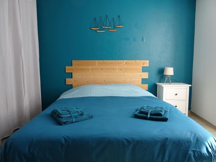 - une chambre bleue avec un lit et 2 serviettes dans l'établissement Maison entre Loire et châteaux, à Menars