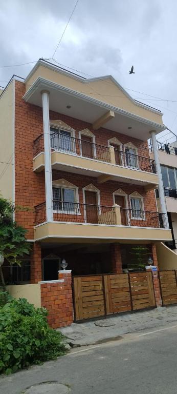 a large brick building with a balcony and gate at Catalyst Suites,Domlur in Bangalore