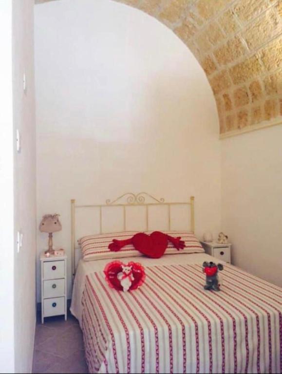 a bedroom with a bed with red pillows on it at Petali Rosa Dimora Rossa in Polignano a Mare
