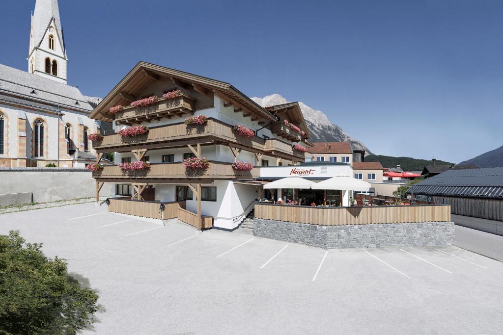 a building with a restaurant in a parking lot at Hotel Neuwirt in Mieming