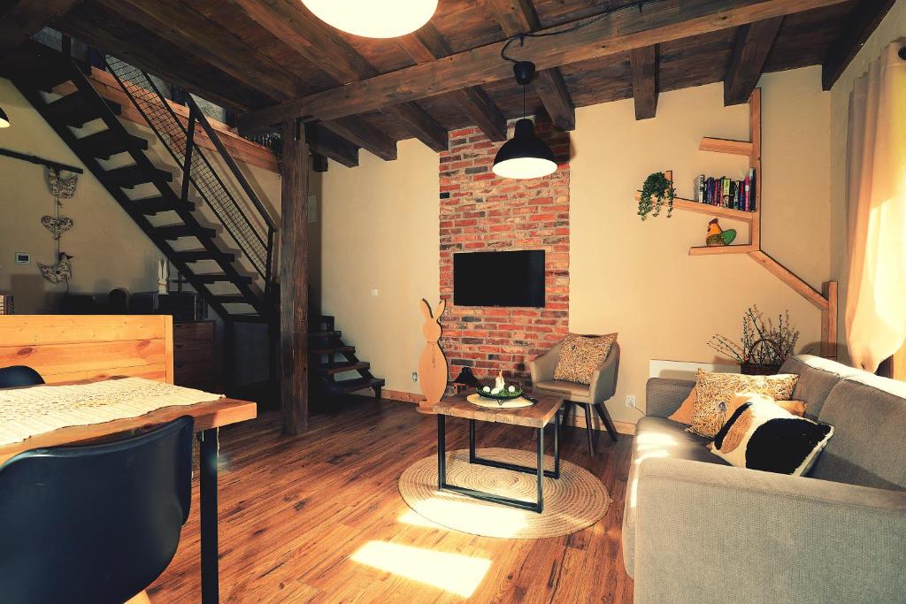 ein Wohnzimmer mit Sofa und Ziegelwand in der Unterkunft OLHA Stara Gajówka in Weremień