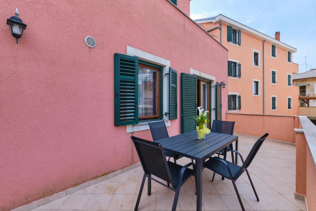 een tafel en stoelen op het balkon van een gebouw bij Apartment Dino 1 in Mali Lošinj