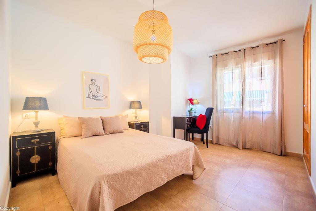 a bedroom with a bed and a desk and a chair at Apartamentos Madrid in Torrevieja