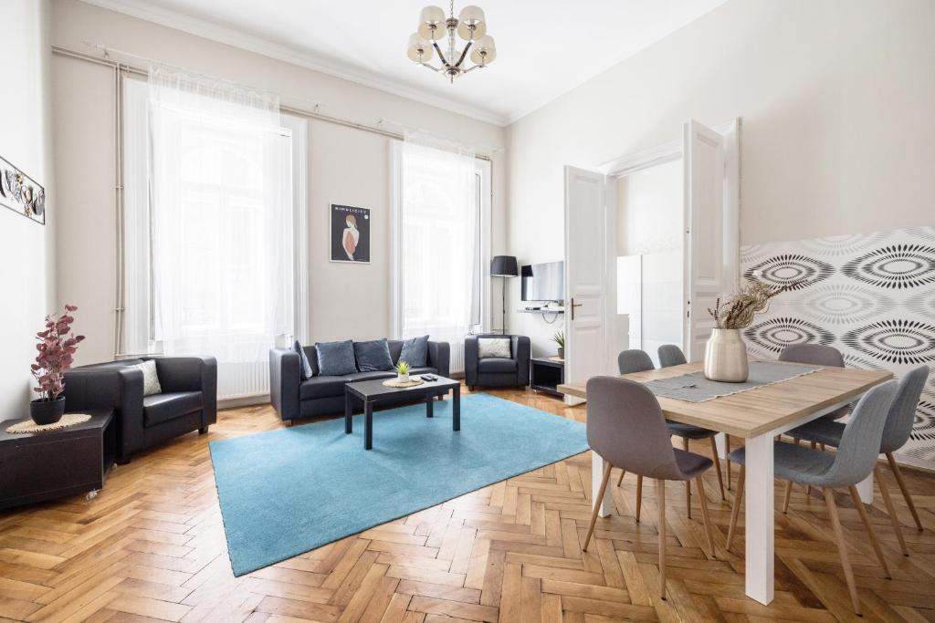 a living room with a table and a blue rug at Elisabeth 52 Apartment in Budapest
