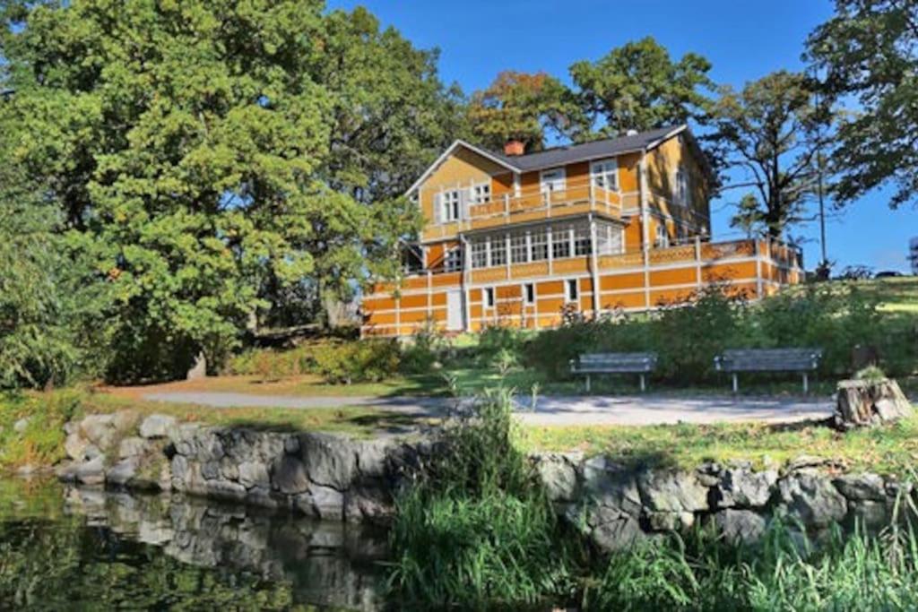 una casa grande sentada junto a un cuerpo de agua en Beautiful lake view house, en Västerås