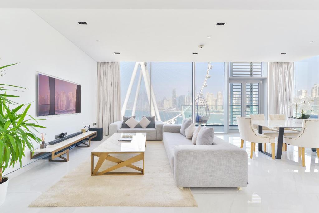 uma sala de estar com um sofá e uma mesa em Spectacular 3 BR condo with maids room facing the Dubai Eye em Dubai