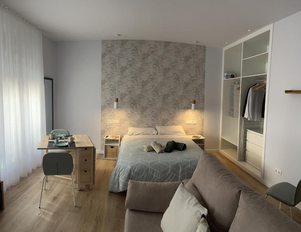 ein Schlafzimmer mit einem Bett, einem Schreibtisch und einem Sofa in der Unterkunft Estudio GVSM in León