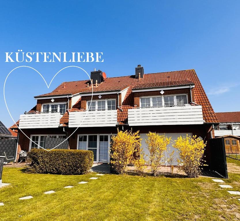 uma casa com um grande quintal em frente em Küstenliebe em Norden