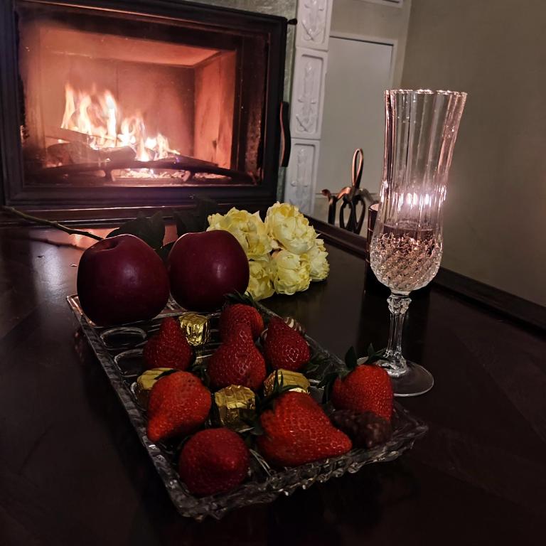 a tray of strawberries on a table with a fireplace at Ventspils apartamenti pie Rātslaukuma in Ventspils