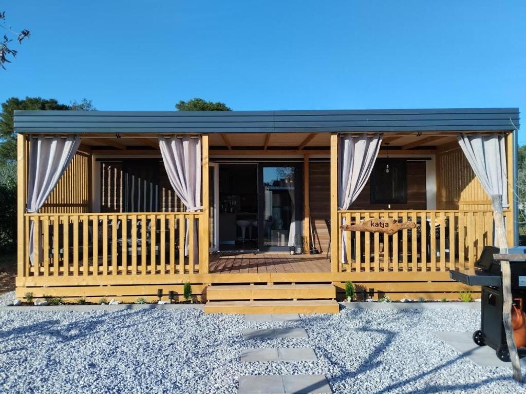 eine Blockhütte mit einer Veranda und einer Terrasse in der Unterkunft Mobile Home Katja in Banjole