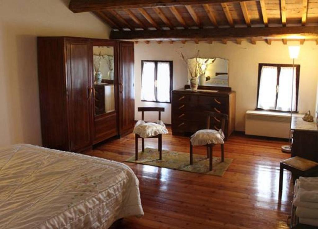 a bedroom with a bed and a dresser and windows at Casarosa B&B in Piazzola sul Brenta