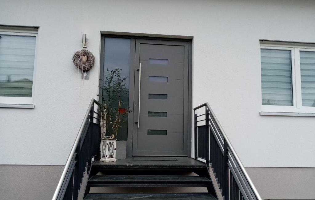 a front door of a white house with stairs at Ferienwohnung Taubertraum in Weikersheim