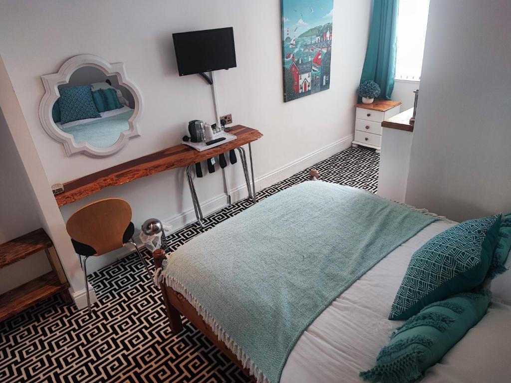 a bedroom with a bed and a mirror on the wall at St Breca in Newquay