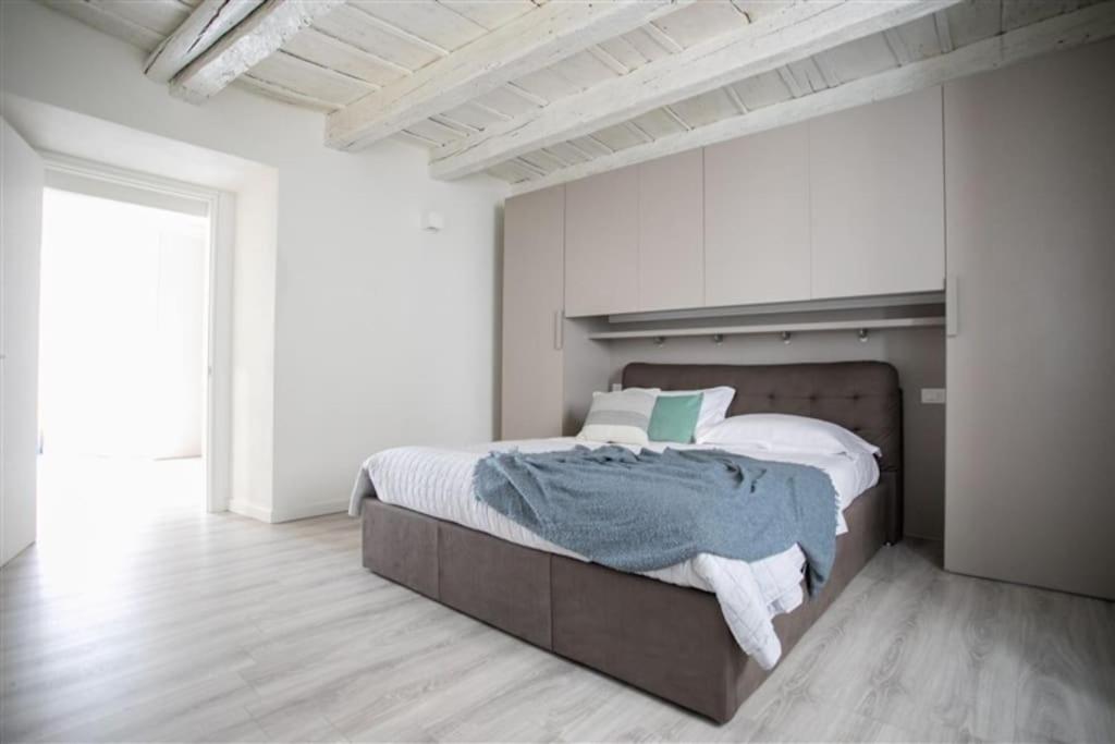 een slaapkamer met een groot bed in een witte kamer bij Fabula Home Rental - Casa Lù in Lovere
