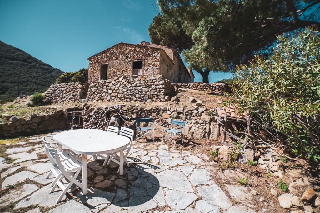 a table and chairs in front of a stone building at Casa Zip in Marciana