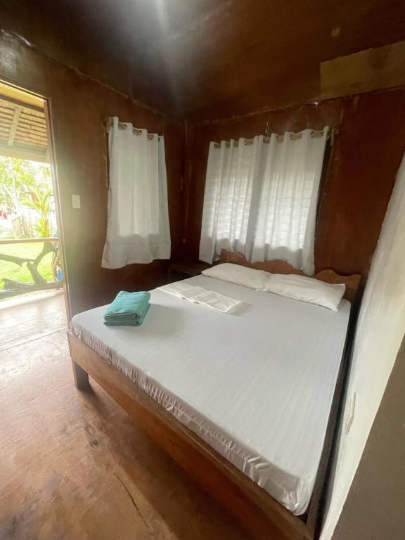 Cama pequeña en habitación pequeña con cortinas en Green Soul Port Barton en San Vicente