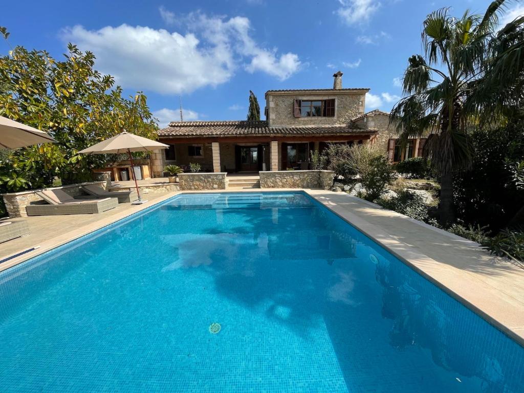 a swimming pool in front of a house at Finca Son Amoyana Capdepera in Capdepera