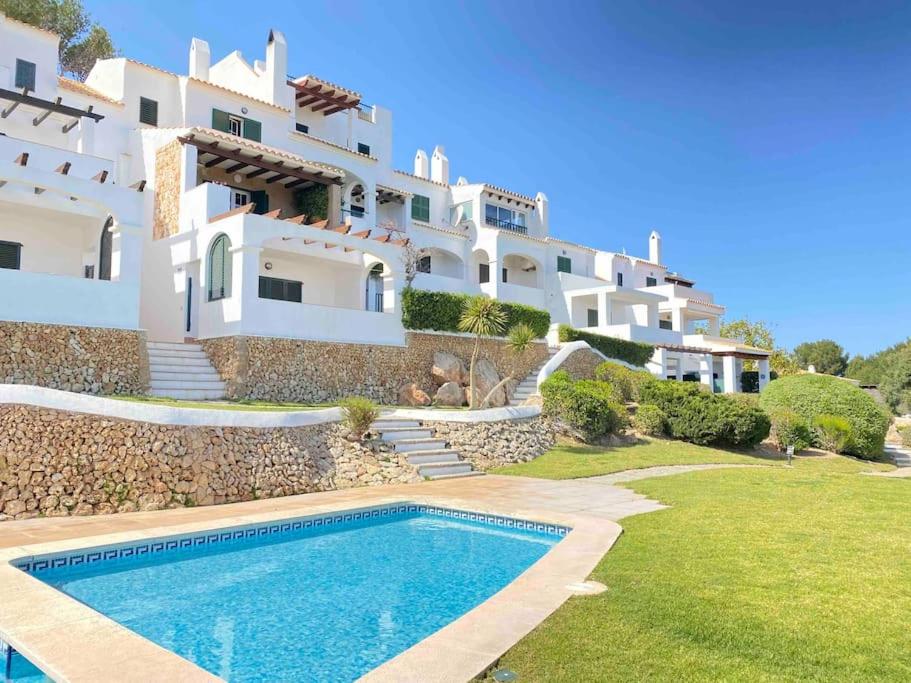 a villa with a swimming pool in front of a building at La Terraza de la Sabina in Es Mercadal