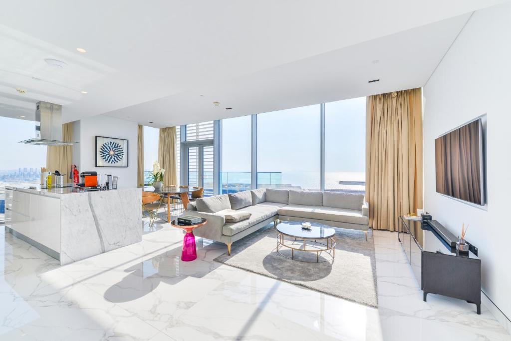 - un salon avec un canapé et une table dans l'établissement Luxe 3 BR Oceanfront Apt with maids room in the heart of Bluewaters Island, à Dubaï