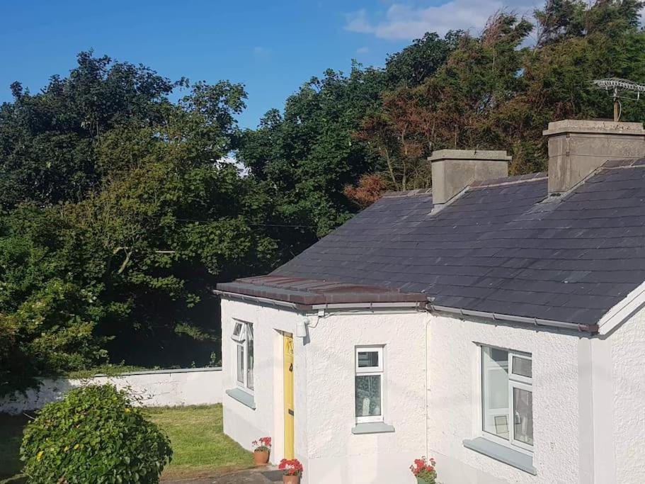 a white house with a black roof at Coastal Cottage in Dromore West