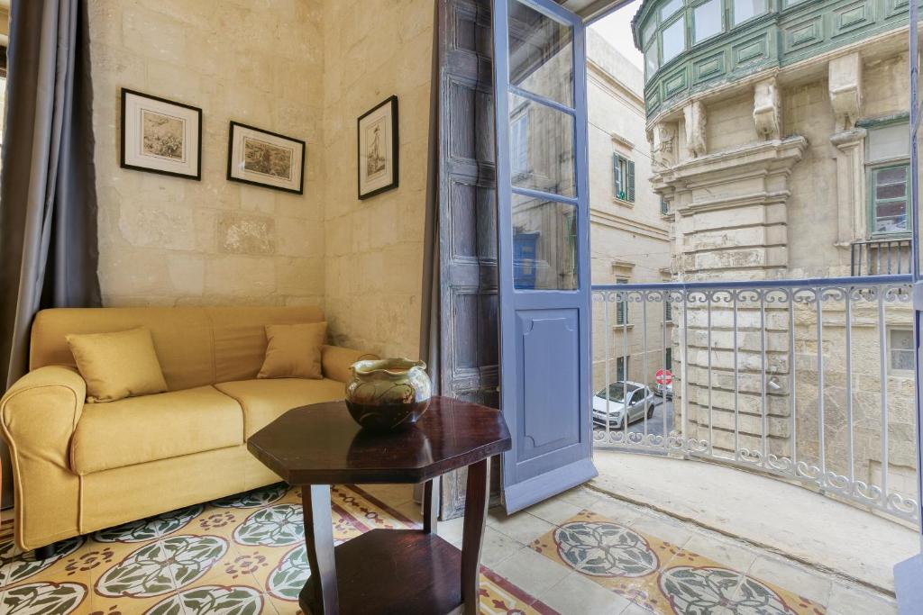 a living room with a couch and a large window at VLT214- Valletta 2 Bedroom Townhouse in Valletta