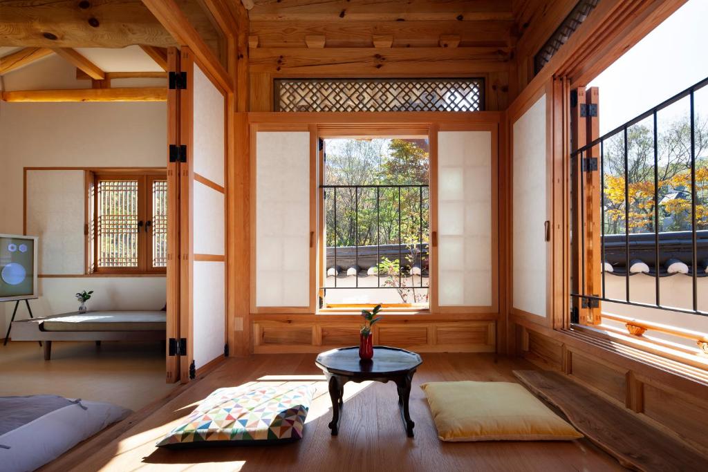a living room with windows and a table at IRIRU Luxury Hanok Stay - Eunpyung Hanok village in Seoul