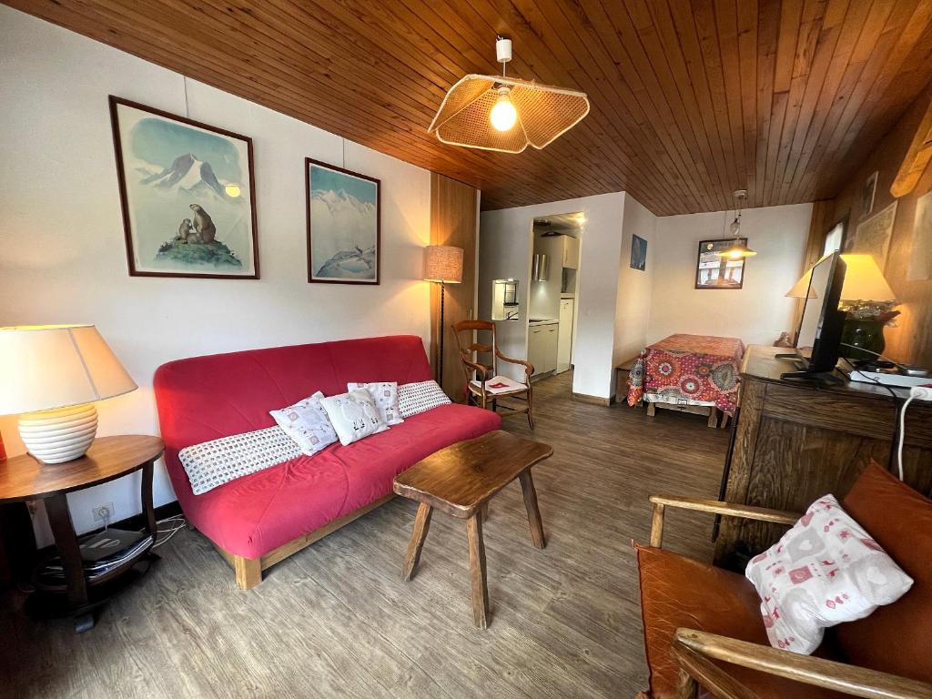 a living room with a red couch in a room at Elan 19 - Appartement 3 chambres in La Clusaz