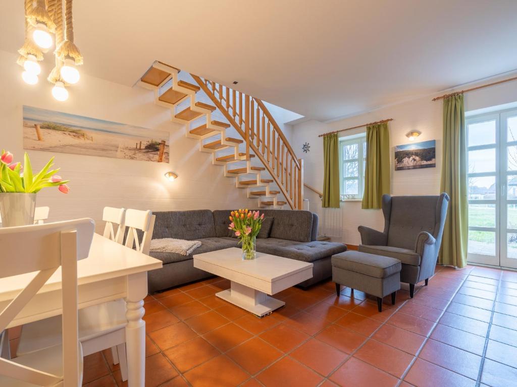 a living room with a couch and a staircase at Feriendorf Rugana - Komfort Appartement mit 2 Schlafzimmern und Terrasse D03 in Dranske
