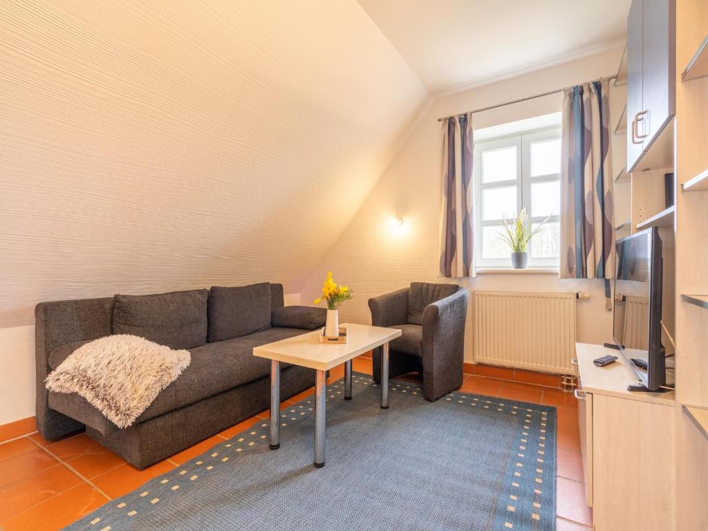 a living room with a couch and a table at Feriendorf Rugana - Klassik Appartement mit 1 Schlafzimmer D15 in Dranske
