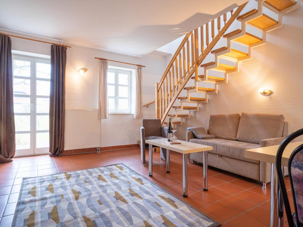 un salon avec un canapé et un escalier dans l'établissement Feriendorf Rugana - Budget Appartement mit 2 Schlafzimmern und Terrasse A26, à Dranske
