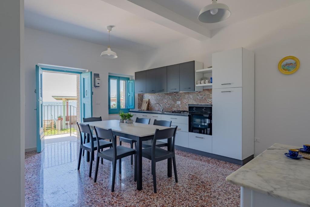 La casa di Maria - YourPlace Abruzzo في فوساتشيزيا: مطبخ مع طاولة وكراسي في غرفة