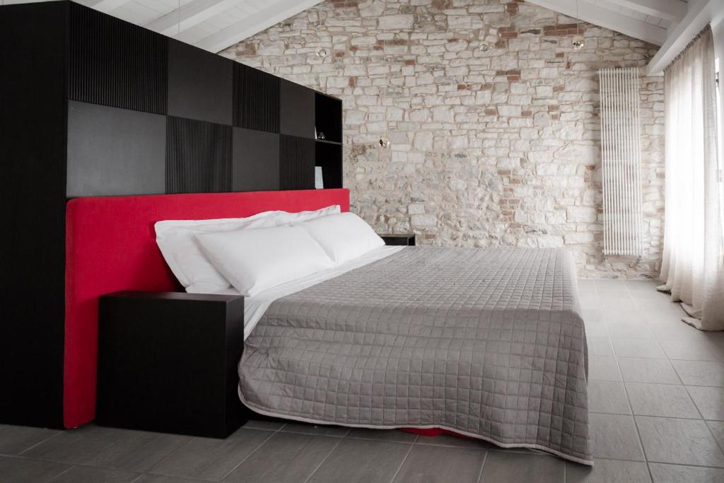 a bedroom with a bed and a brick wall at Casa dell'Artista in Valdobbiadene