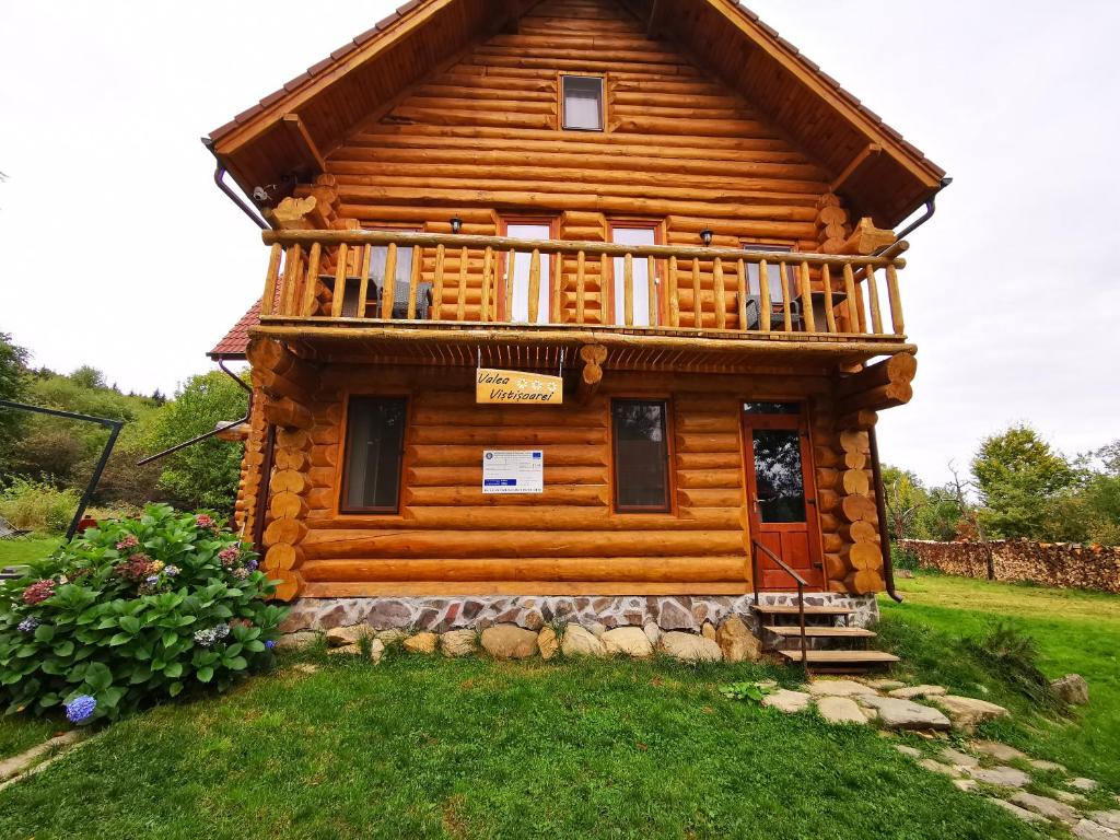 una baita di tronchi con veranda e balcone. di Valea Vistisoarei a Vistisoara