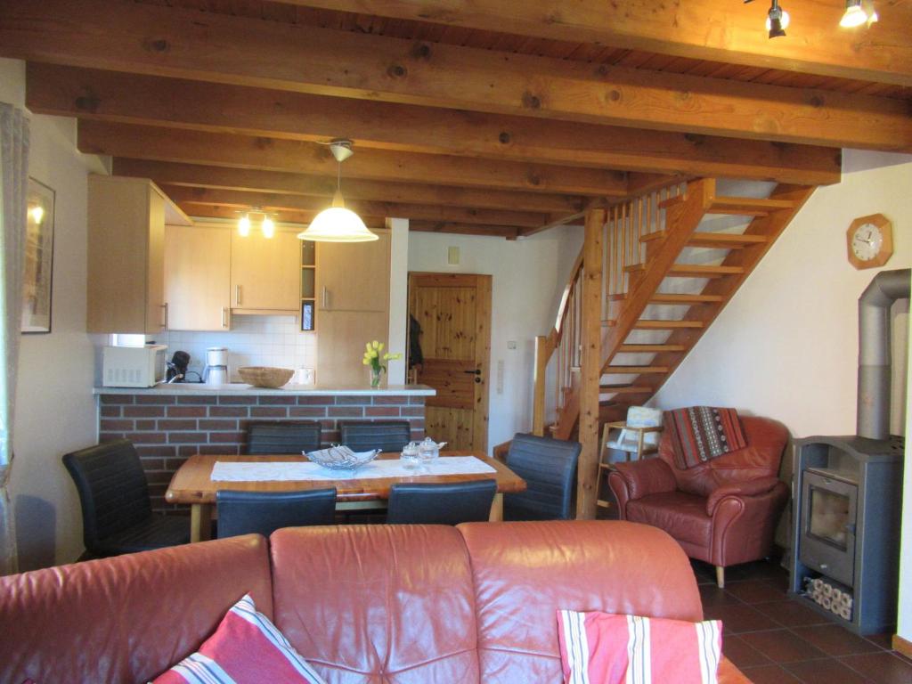 ein Wohnzimmer mit einem Sofa und einem Tisch sowie eine Küche in der Unterkunft Ferienhaus Strandfuchs, Hooksiel in Wangerland