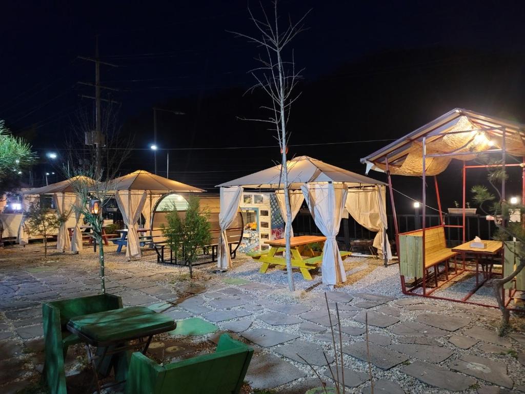 un grupo de tiendas de campaña en un patio por la noche en Sky Vivaldi Pension en Hongcheon