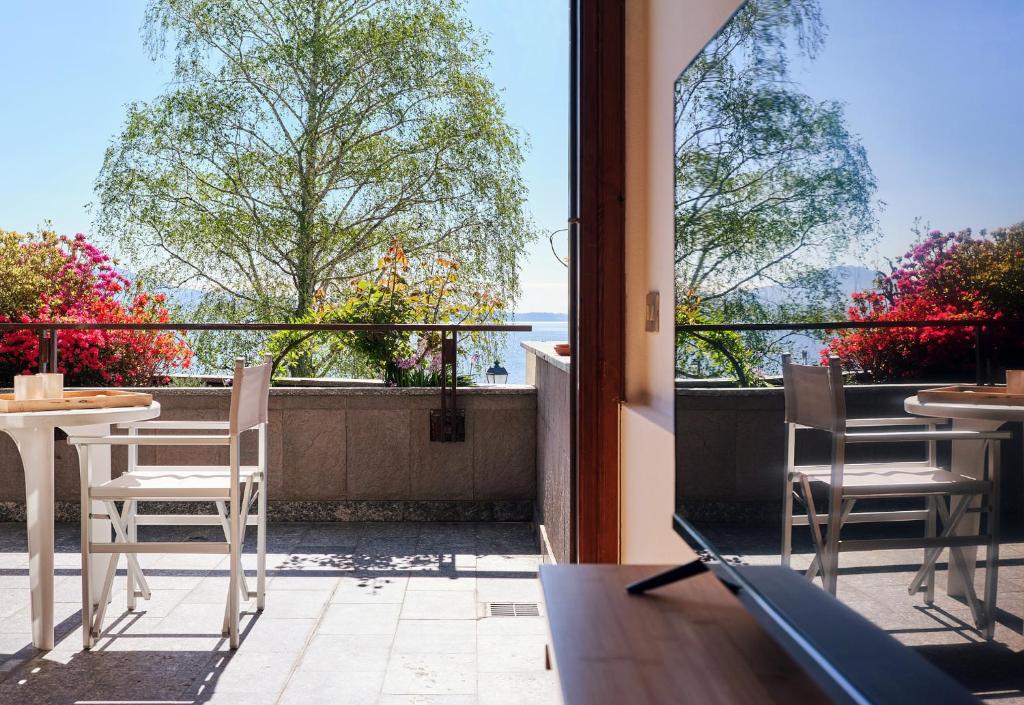 a balcony with chairs and tables and a view of the ocean at APPARTAMENTO GHITA in Baveno