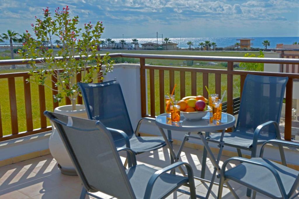 a table with chairs and a bowl of fruit on a balcony at Villa Rosedale by Ezoria Villas in Ayia Napa