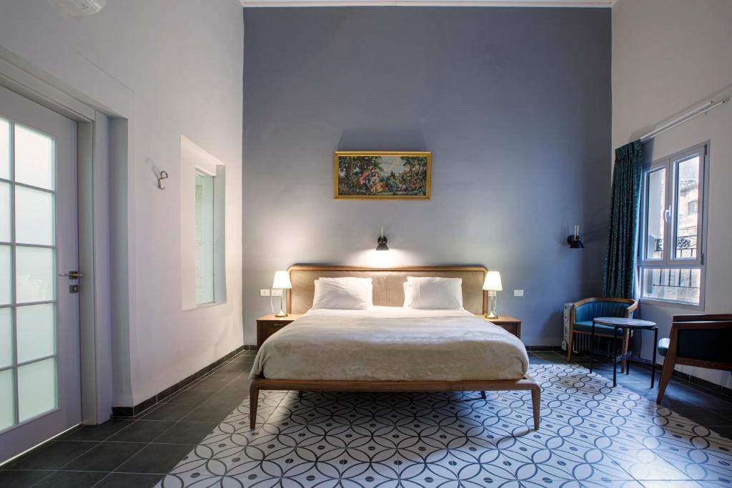 a bedroom with a bed and a blue wall at Michel House in Nazareth